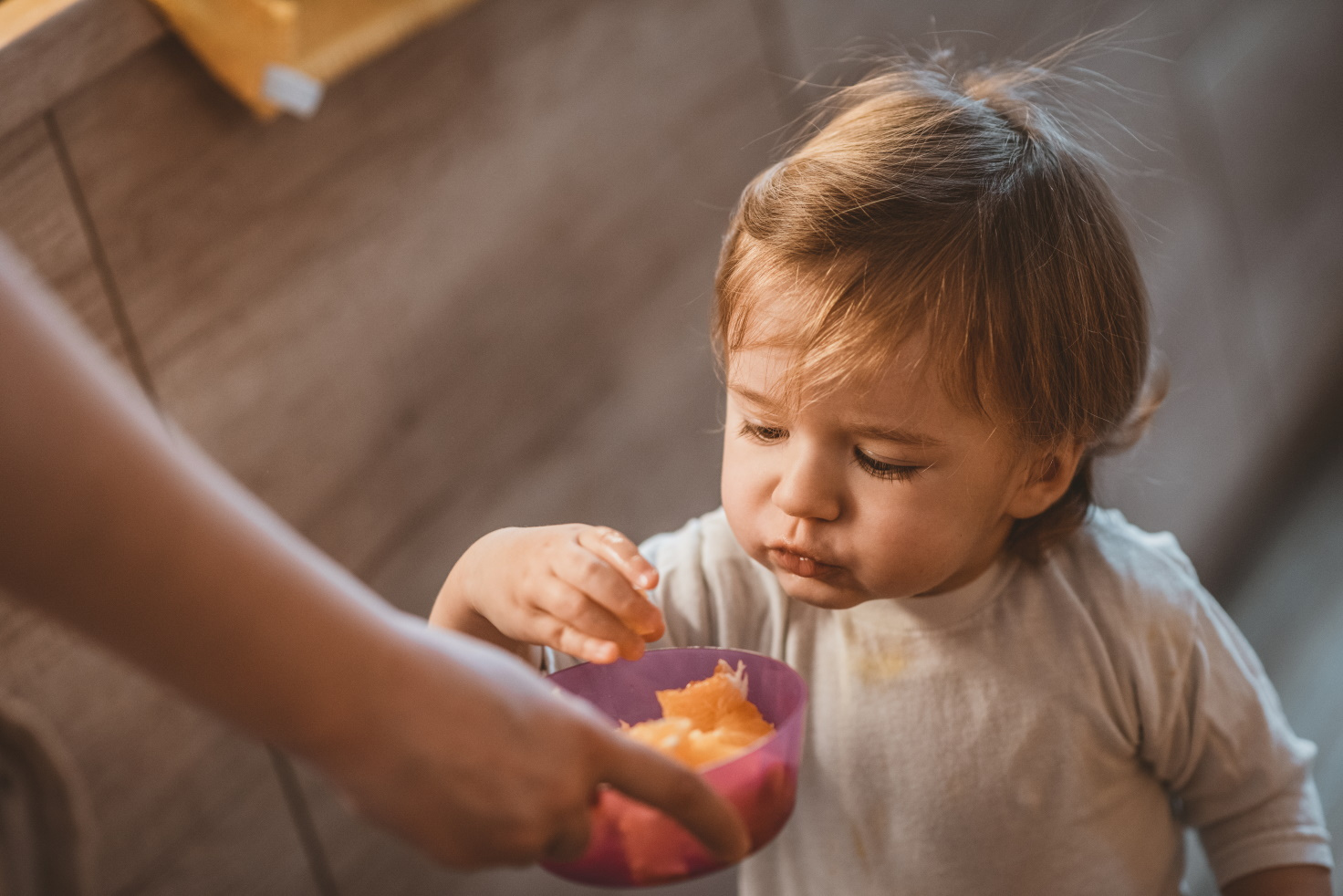 Kleinkind beim Naschen von Obst