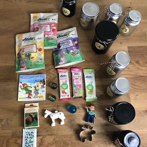 Materialien zum füllen eines Adventskalenders auf einem Holztisch