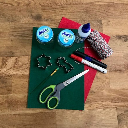 Grüner und roter Filz mit Material zum Basteln auf Holztisch